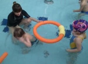 Dzieci uczą się zanurzać główkę - należy pod powierzchnią wody do kółeczka wejść i z niego wyjść.